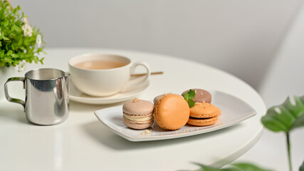 Coffee table with French colourful macarons and tea cup in living room