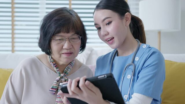 Young asia female nurse, assisted living, in-home carer or doctor visit old senior citizen at home talk about result follow up checklist, health care advice or prescription online on tablet computer.