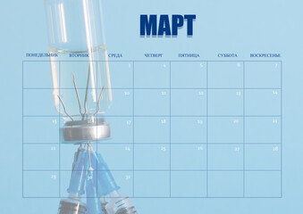 A clean desktop calendar for March, for the doctor. The layout used as the schedule planner. A bottle of medicine and needles of syringes in the background. All inscriptions are in Russian