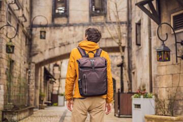 Fototapeta premium Young man tourist walks down the street in a European city after the end of COVID-19 coronavirus. quarantine is over
