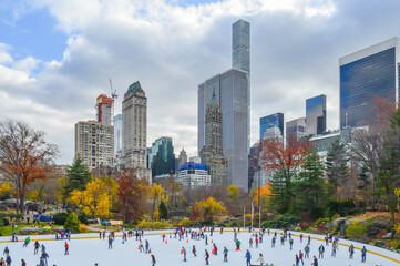 City of NYC, New York City during December, winter time at the skating rink in central park on blue...