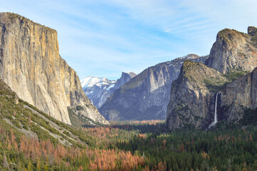 Yosemite Valley in California, National Park area on a stunning day showing a waterfall, flowing down a rock face. 