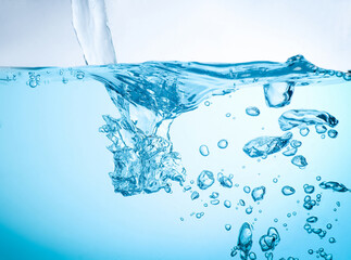 The flow of water creates a splash and the blue waves underwater, and the bubbles naturally flow to...