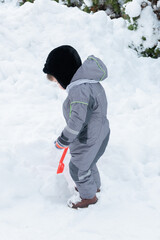 Fototapeta na wymiar Toddler baby outdoors on snow background. Boy playing with a shovel outdoors. Winter boy. Snowy winter.
