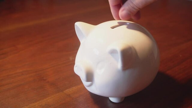 Putting coins in a pig-shaped safe