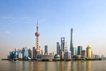 Fototapeta premium City of Shanghai in China, taken on a blue sky day in summer time with the Huangpu River running in front of the CBD, main city area. 