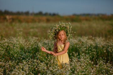 little girl in the field with a wreath on her head walking summer