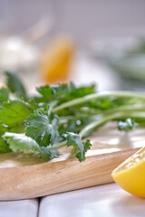 Spicy herb watercress salad with olive oil and lemon on a wooden board on a white plate close up