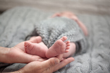 Close-up of newborn legs in woman hands