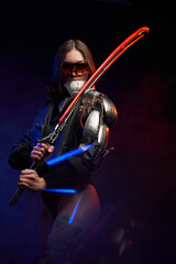 Atmospheric portrait of a beautiful female assassin posing in dark background with smoke. Armed with glowing sword military woman with sunglasses and implant.