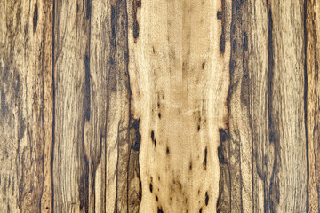 Texture of elegant contemporary Black Ofram natural veneer with abstract beige and brown patterns as background extreme closeup