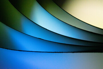 Background macro image pattern made of folded curved sheets of paper with multi color light illuminate  