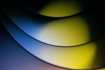 Background macro image pattern made of folded curved sheets of paper with multi color light illuminate  