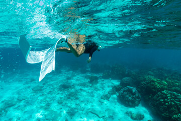 woman swimming freediving to see coral reefs.