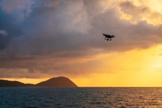 drone flying in the sunset to take pictures of the sea.
