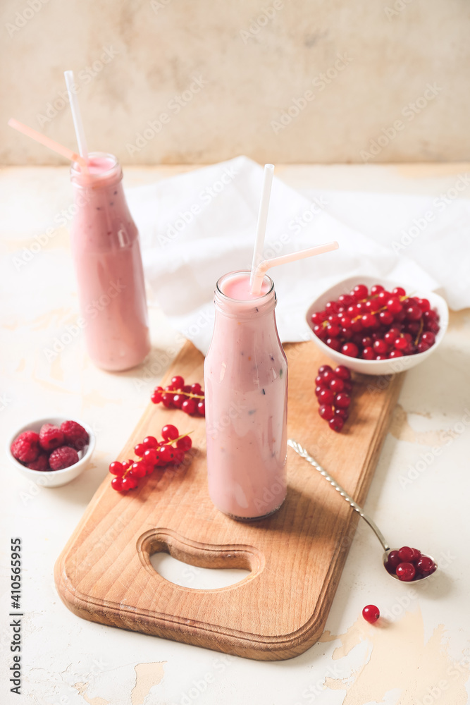 Canvas Prints bottles of tasty smoothie with cranberry and raspberry on light background
