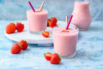 Glasses and jug with yummy strawberry smoothie on color background