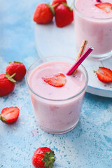 Glasses with yummy strawberry smoothie on color background
