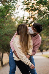 Fototapeta premium couple kissing with masks, happy latin couple