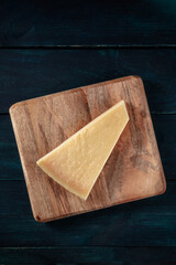 Parmesan cheese, shot from above on a dark blue background with copy space