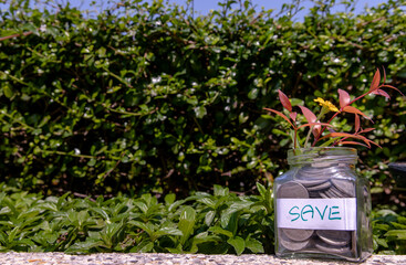The pile of coins in glass bottle on natural green background for concept for growth and saving...