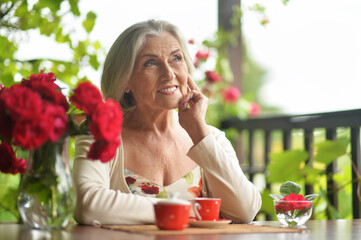 Portrait of a happy aged woman  drinking coffee