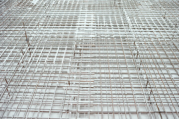 Obraz premium Metal armature net for building construction. Reinforcements steel bars stack. Building materials, formwork, metal structures. Construction site in winter.