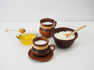 Breakfast in earthenware decorated with handmade birch bark. Farmed organic dairy products. Cow's milk, fresh cottage cheese, natural honey for breakfast