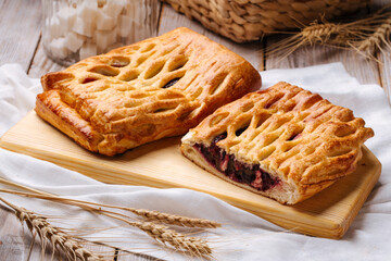 Side view on fresh baked berry jam pie on the wooden cutting board