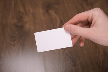 Hand hold blank white card mockup with rounded corners. Plain call-card mock up template holding...