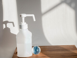 消毒液と地球。新型コロナウイルス(COVID-19)や感染症の予防対策イメージ。	