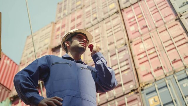 Senior cargo manager hand hold radio control working process near  Container cargo harbor crane ,caucasian male docker Logistics import export shipping concept.