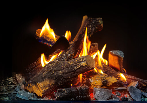 Wood logs burning in fireplace close up