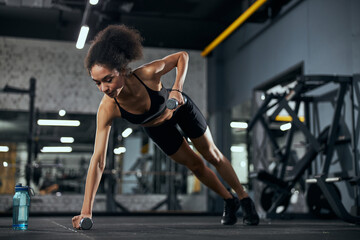 Fototapeta na wymiar Kind international sportswoman doing fitness at the gym
