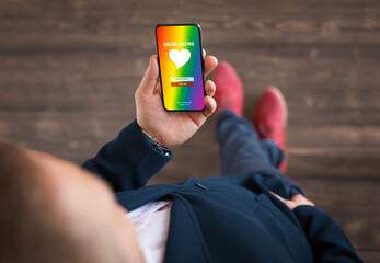 Man using gay and LGBT community dating app on his mobile phone - obrazy, fototapety, plakaty