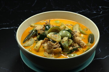 Thai spicy curry soup of eggplant and chicken serving in the bowl. Famous traditional hot and spicy food in Asia restaurant. 