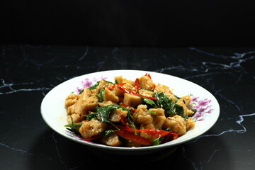 Traditional fried and stirred spicy chopped shrimp ball mixed with chilly and basil serving on the plate. 