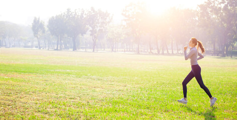 Obraz na płótnie Canvas Young beautiful woman running on grass field at morning
