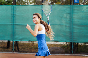 Beautiful, young woman athlete enjoys spending time on the tennis court. Powerful blow forehand. Preparing to receive the ball from the opponent. As focused and collected as possible