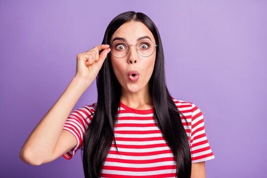 Photo of attractive surprised young woman hold wear glasses unexpected sale isolated on violet color background