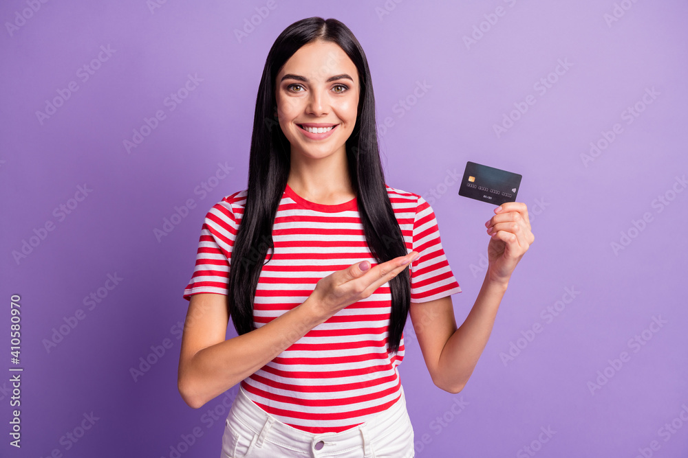 Wall mural Photo of positive brunette lady point hand hold credit card offer ad product isolated on violet color background