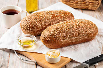 Side view on loafs of wheat and rye flour bread with butter on the wooden background