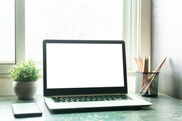 Fototapeta premium Laptop computer with mockup or blank screen on desk in workspace and copy space concept