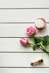 Top view arrangement with make-up, roses and copy-space on white wooden background