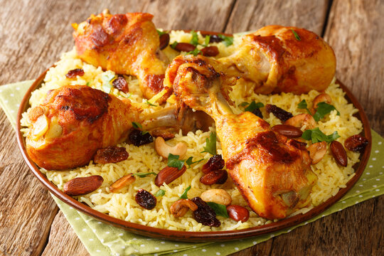 Majboos is a traditional Arabian Rice dish incorporating chicken meats closeup in the plate on the table. horizontal