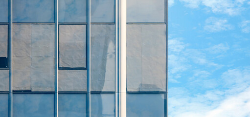 unsold real estate, windows of abandoned condominium with crumple paper attachment against blue sky, concept of real estate crisis or housing bubble