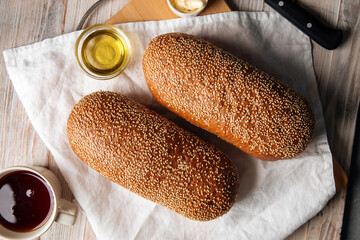 Top view on loafs of wheat and rye flour bread with butter on the wooden background