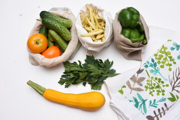 Fresh vegetables in white eco storage bags. Tomatoes, peppers, zucchini, cucumbers, beans. Zero waste concept.