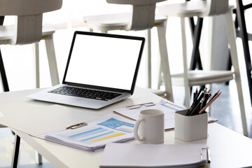 Laptop computer with mockup or blank screen on white desk in workspace and copy space concept