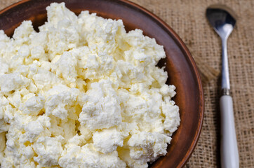 Close-up of fresh cottage cheese in a clay bowl.